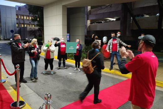 woman walks on red carpet as people applaud