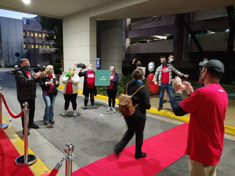 woman walks on red carpet as people applaud