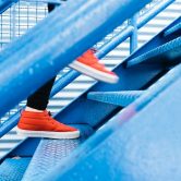 red sneakers going up blue stairway