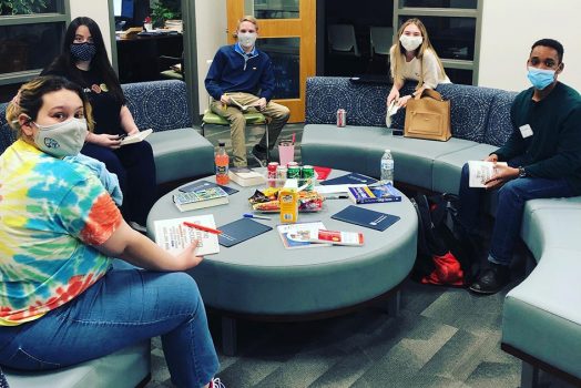 Five students sitting in a circle