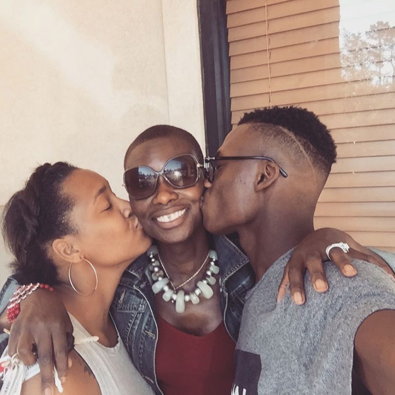 Two teen kids kissing mom on the cheek