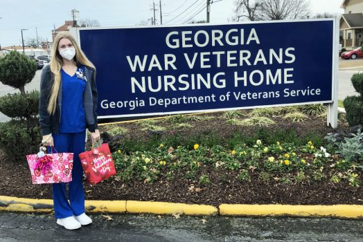 Woman with bags in front of sign