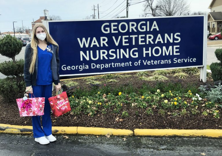 Woman with bags in front of sign