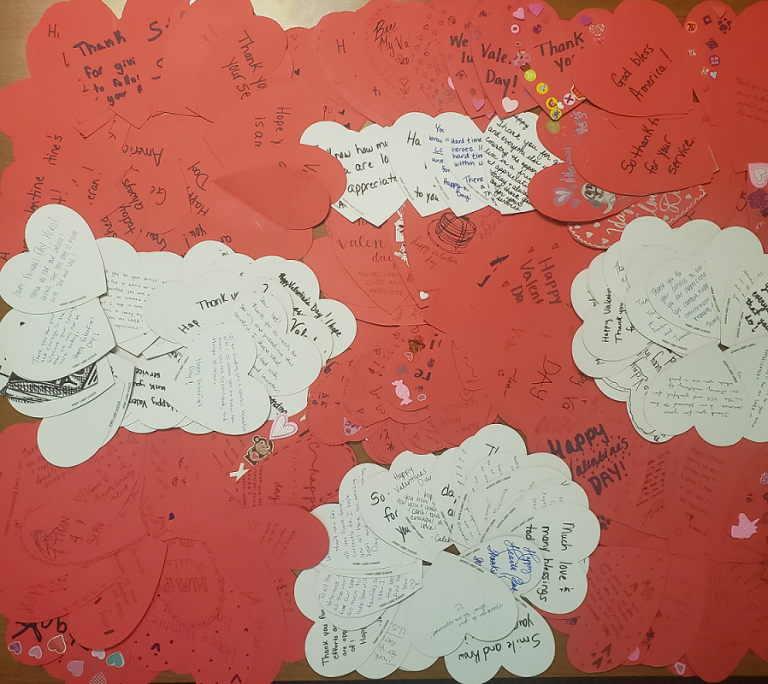 pile of red and white paper hearts with notes written on them