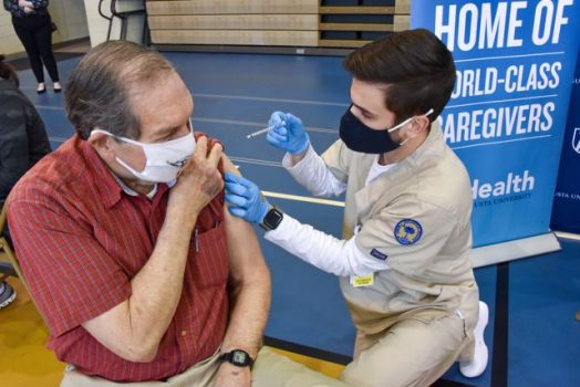 A man getting a shot from a nurse.