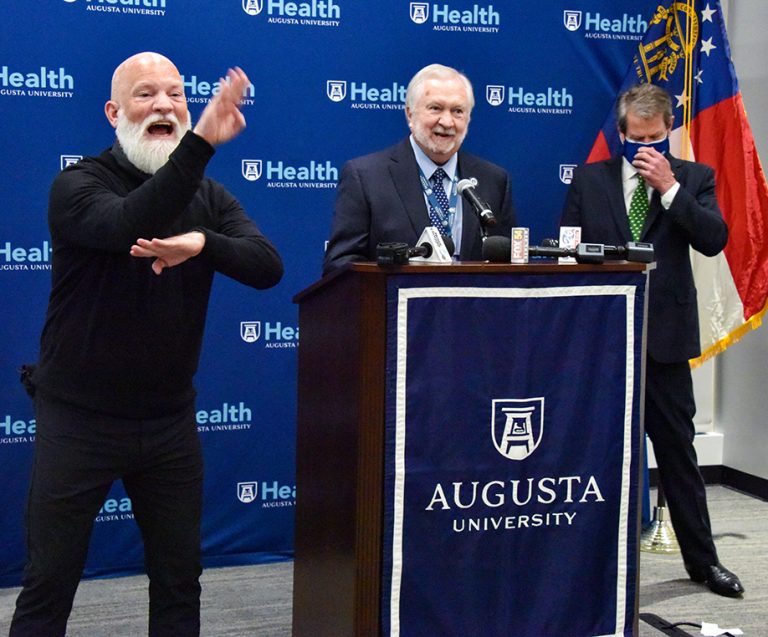 Man at podium and man doing sign language