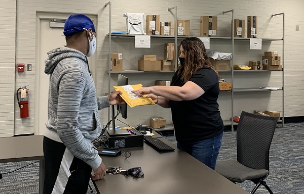 student accepts envelope from mail person