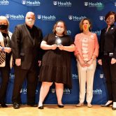 woman holds award in group with three other women and man