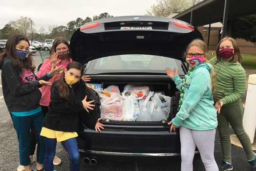Students with a trunk full of groceries in bags