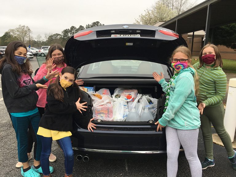Students with a trunk full of groceries in bags