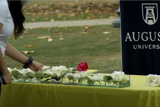Woman putting flowers in a container of water.