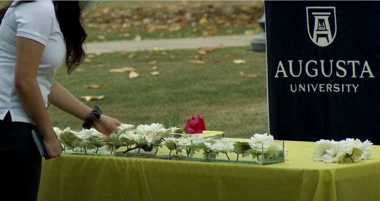 Woman putting flowers in a container of water.