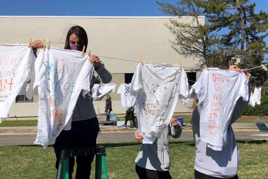 female student hangs up shirt on clothesline