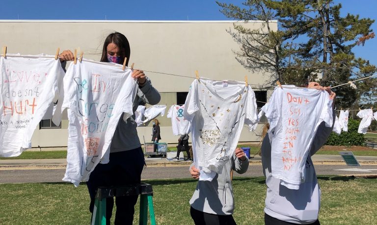female student hangs up shirt on clothesline