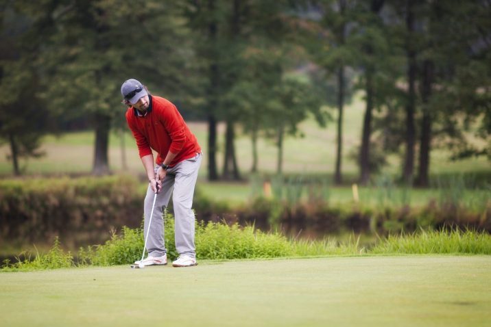 Golfer swinging at a ball.