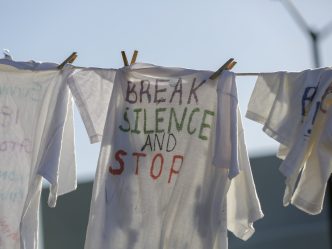 shirt on clothesline says 'Break Silence and Stop Violence'