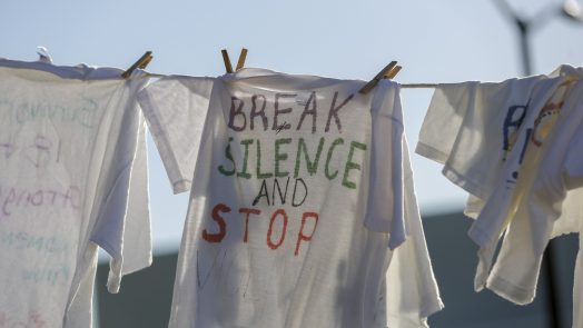 shirt on clothesline says 'Break Silence and Stop Violence'