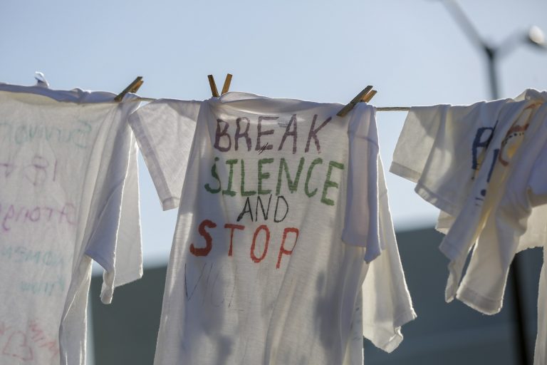 shirt on clothesline says 'Break Silence and Stop Violence'