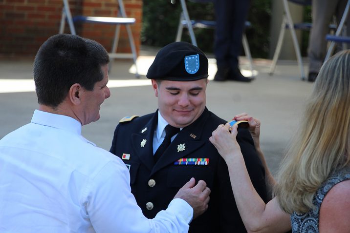 People pinning male cadet