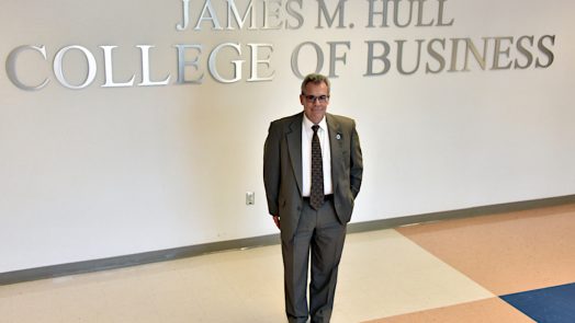 Dean of Hull College standing by sign.