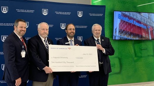 four men hold big check