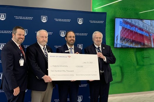 four men hold big check