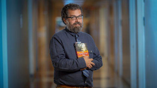 man in blue shirt holding a book