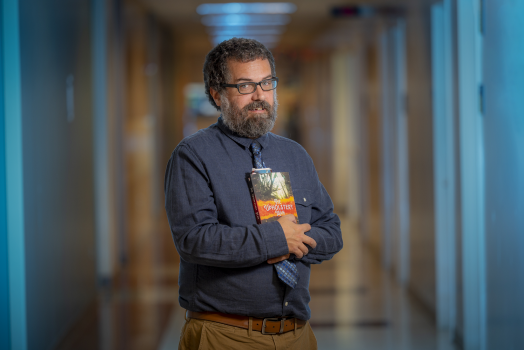 man in blue shirt holding a book