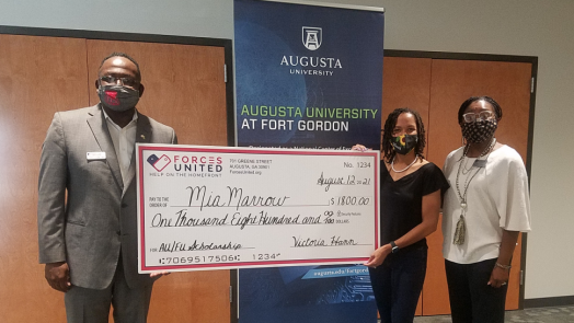 Three people holding check