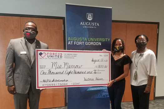 Three people holding check