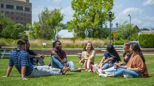 students sitting in grass