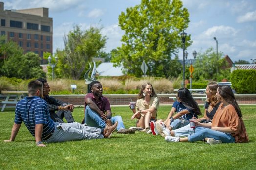 students sitting in grass