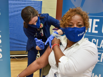 a woman administers a vaccine to another woman