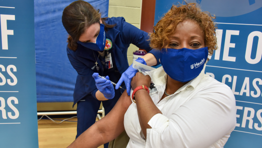 a woman administers a vaccine to another woman