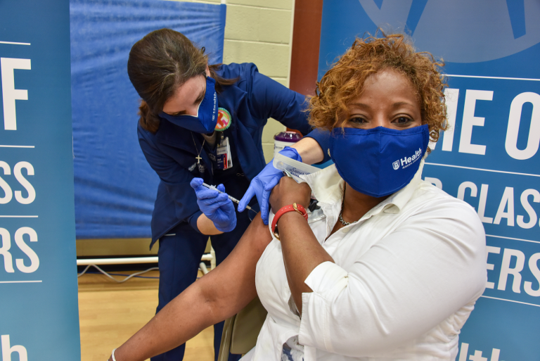 a woman administers a vaccine to another woman