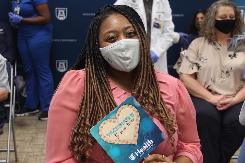 Woman holding vaccinated sign