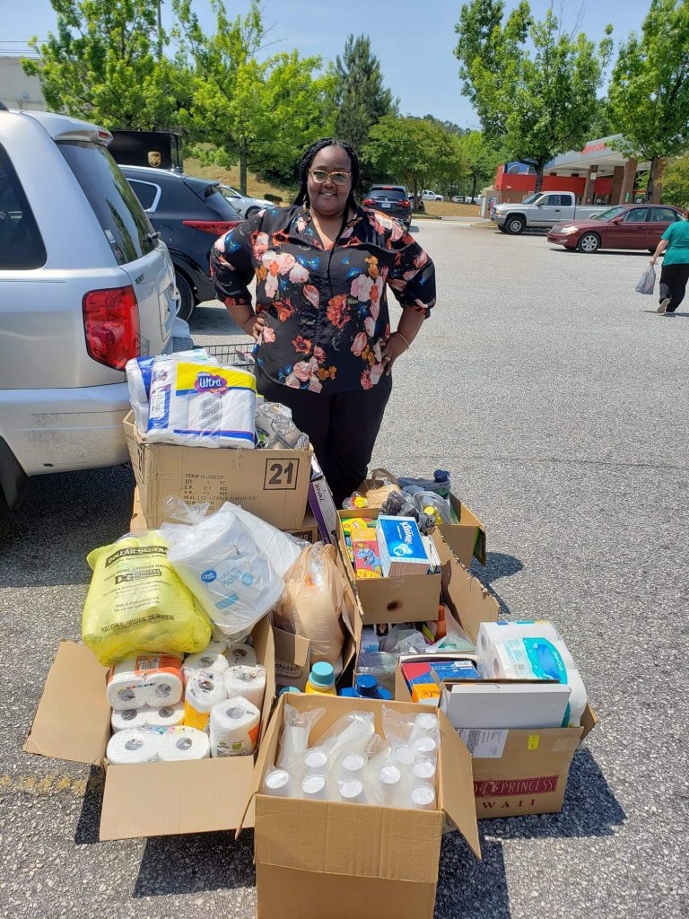 woman standing near boxes of food and supplies