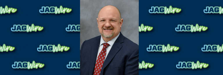 headshot of a man in a red tie