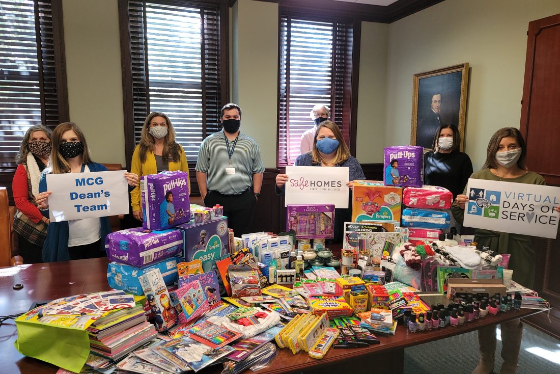 8 people, wearing masks, standing next to art supplies and toiletries