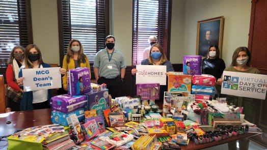 8 people, wearing masks, standing next to art supplies and toiletries