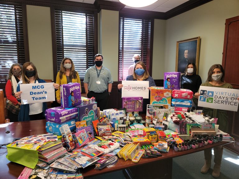 8 people, wearing masks, standing next to art supplies and toiletries