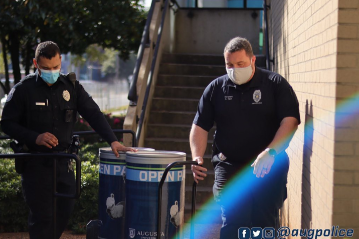 two police officers moving trash cans