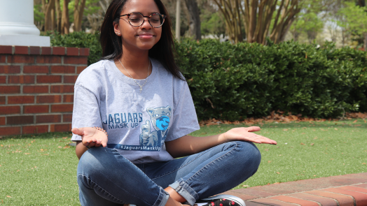 woman wearing glasses meditates outdoors