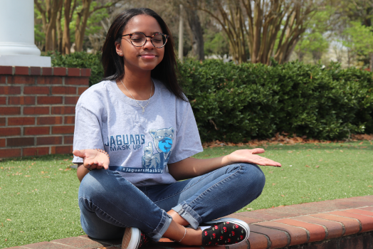 woman wearing glasses meditates outdoors