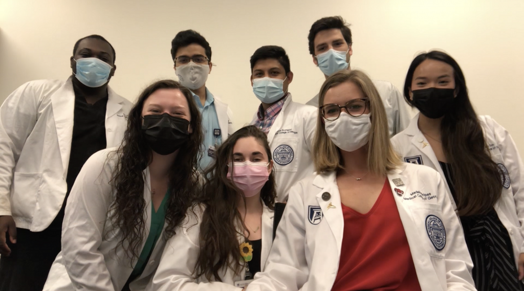 8 medical students wearing masks, smiling for picture