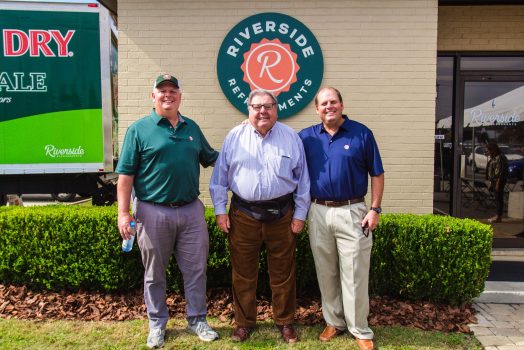 Three men in front of business