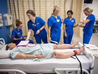 medical students practicing clinicals on a dummy