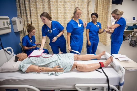 medical students practicing clinicals on a dummy