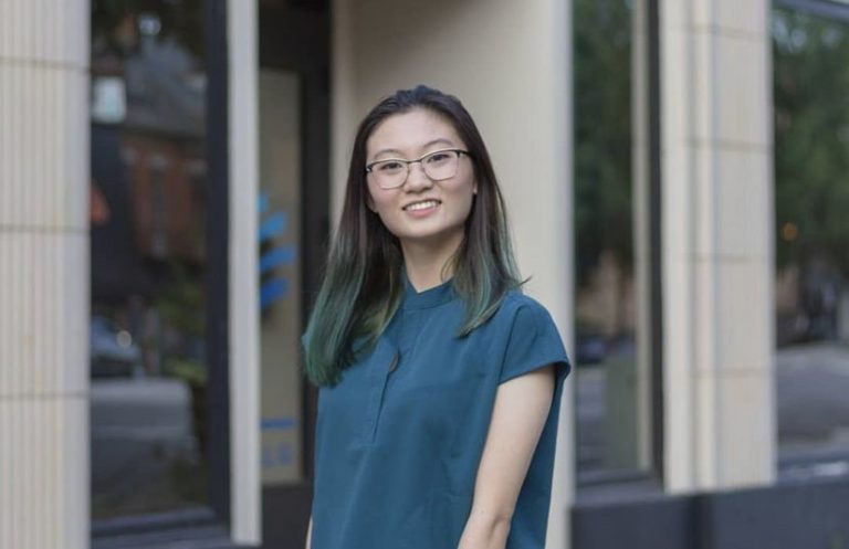 Dental student posing in scrubs.