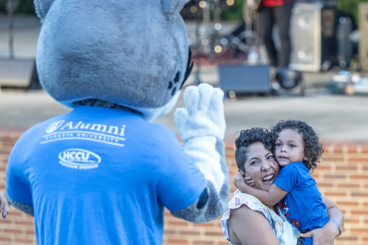 woman and child smiling at mascot